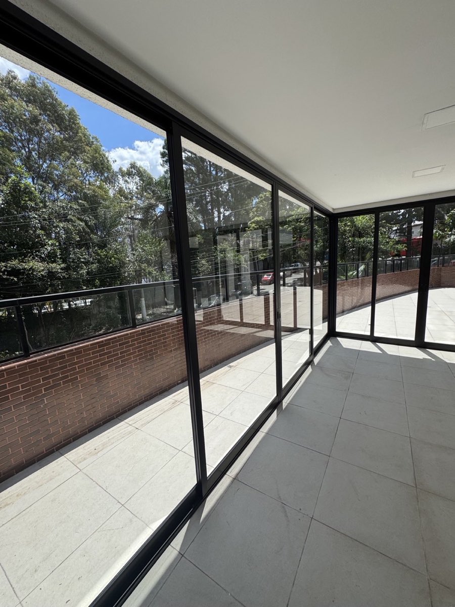 Porta de correr de 4 folhas em alumínio preto da linha Suprema, vista interna da varanda. Obra da VitraAlu em Jardim São Paulo, São Paulo.