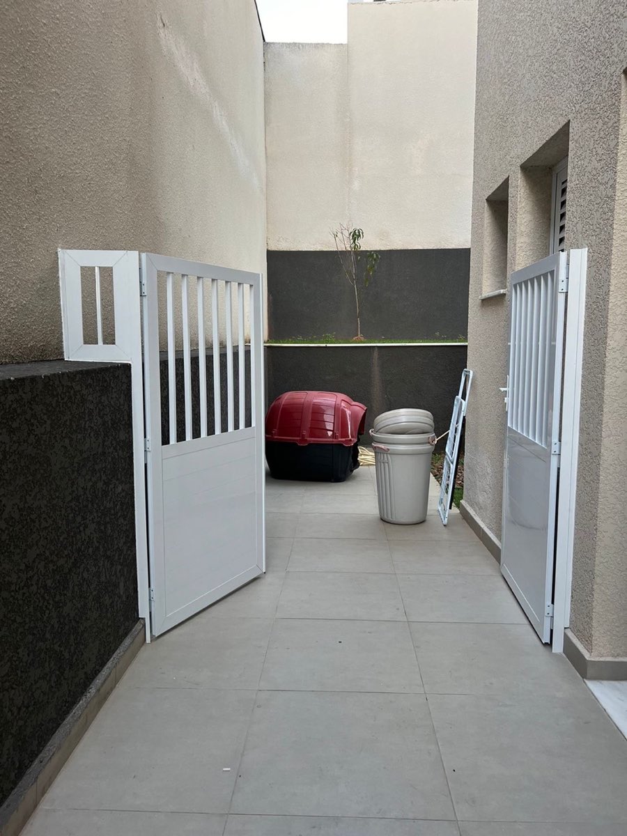 Portão de duas folhas em alumínio branco com gradil vertical. Obra da VitraAlu em Alphaville, Barueri.