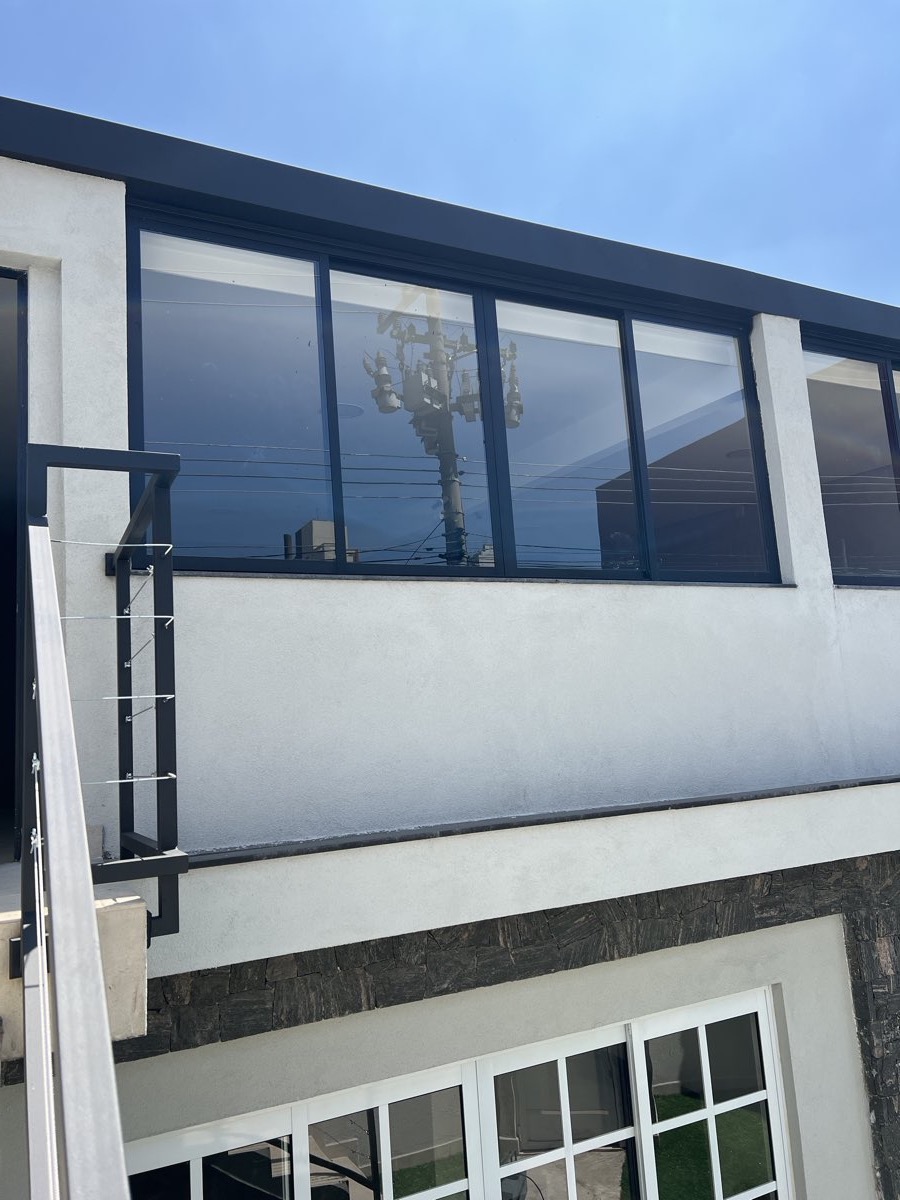 Fachada de imóvel com fita corrida de janelas em alumínio preto e vidro, vista da rua. Obra da VitraAlu em Anália Franco, São Paulo.