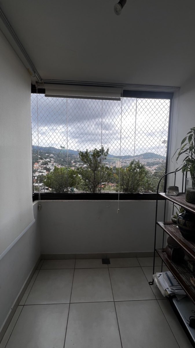Sacada de apartamento fechada com envidraçamento de vidro retrátil e vista para a cidade. Obra da VitraAlu em Tucuruvi, São Paulo.