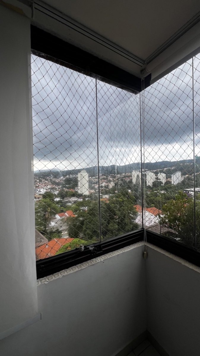 Sacada envidraçada com painéis de vidro recolhidos, vista ampla para a cidade. Obra da VitraAlu em Tucuruvi, São Paulo.
