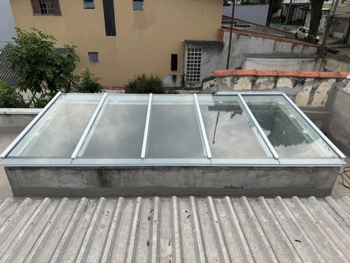 Cobertura de vidro sobre quintal, com estrutura de alumínio branco. Obra da VitraAlu em Pinheiros, São Paulo.
