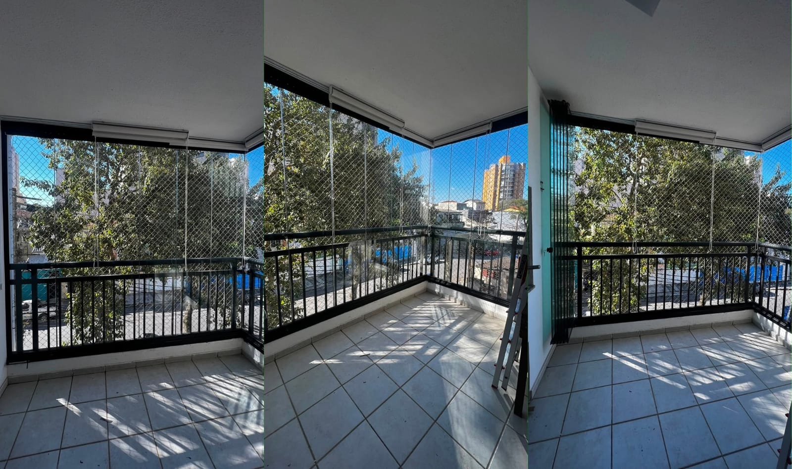 Varanda em L de apartamento fechada com vidro e esquadria preta, com tela de proteção e vista para o bairro. Obra da VitraAlu em Butantã, São Paulo.